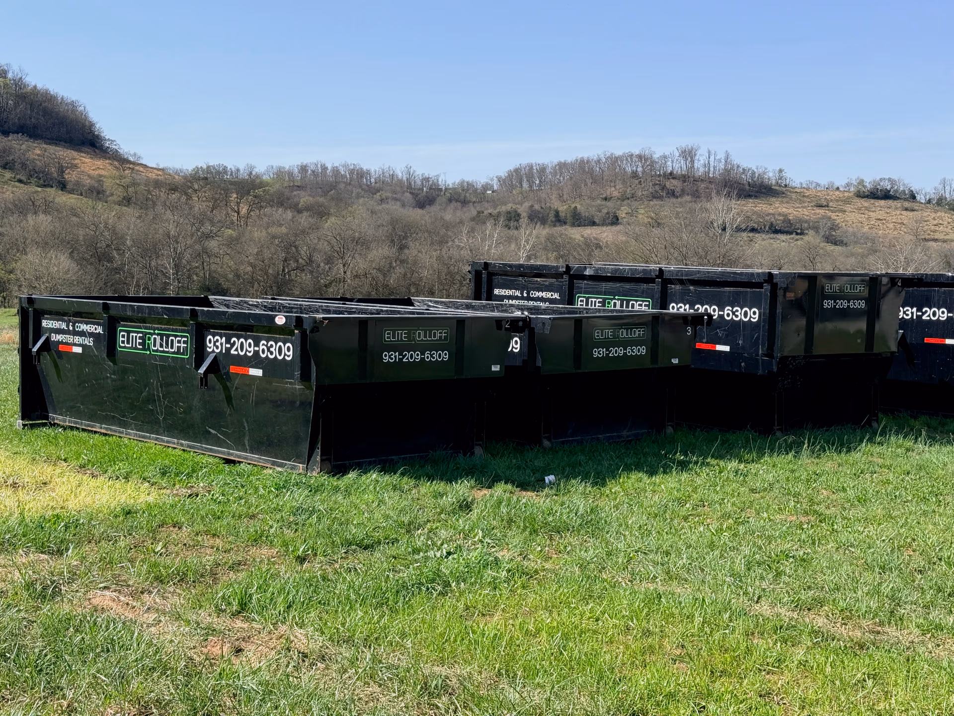 Multiple roll off dumpsters ready for rental at Elite Rolloff yard in Fayetteville TN